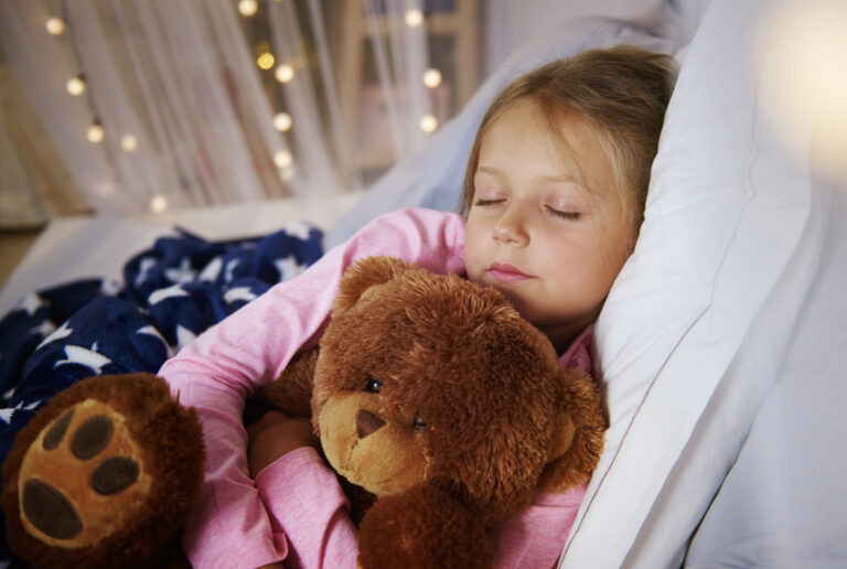 Small girl sleeping with teddy bear